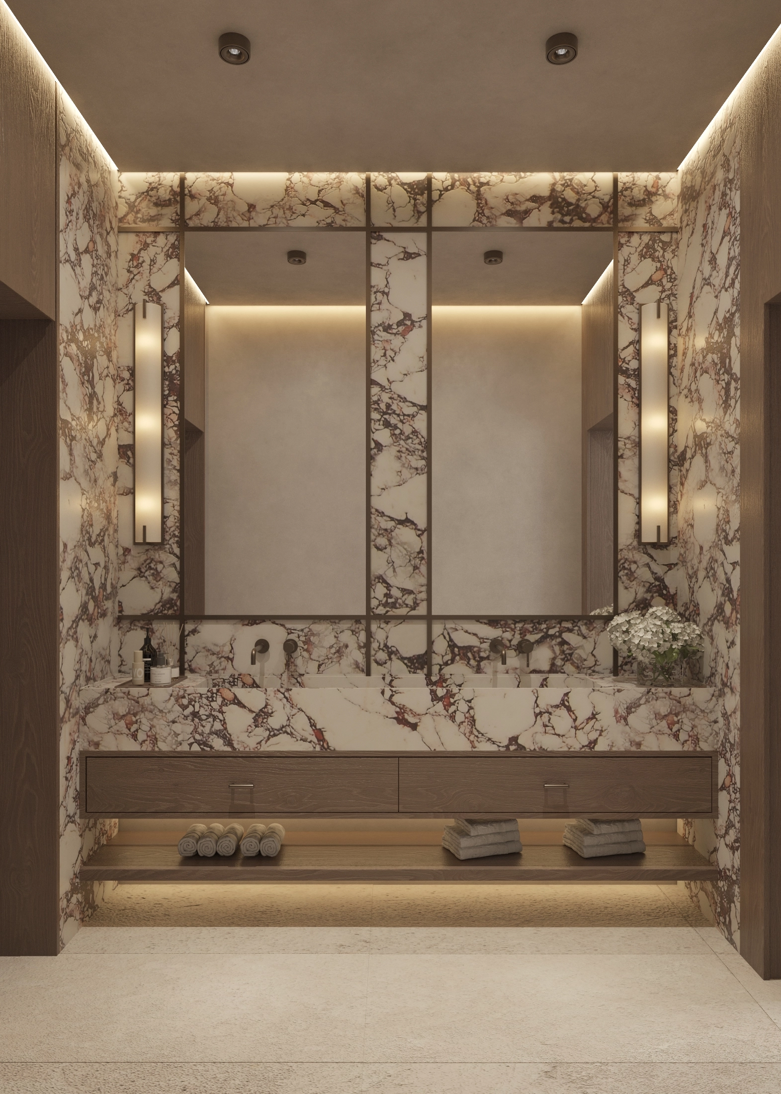 Front view of a richly veined marble vanity and illuminated mirrored wall