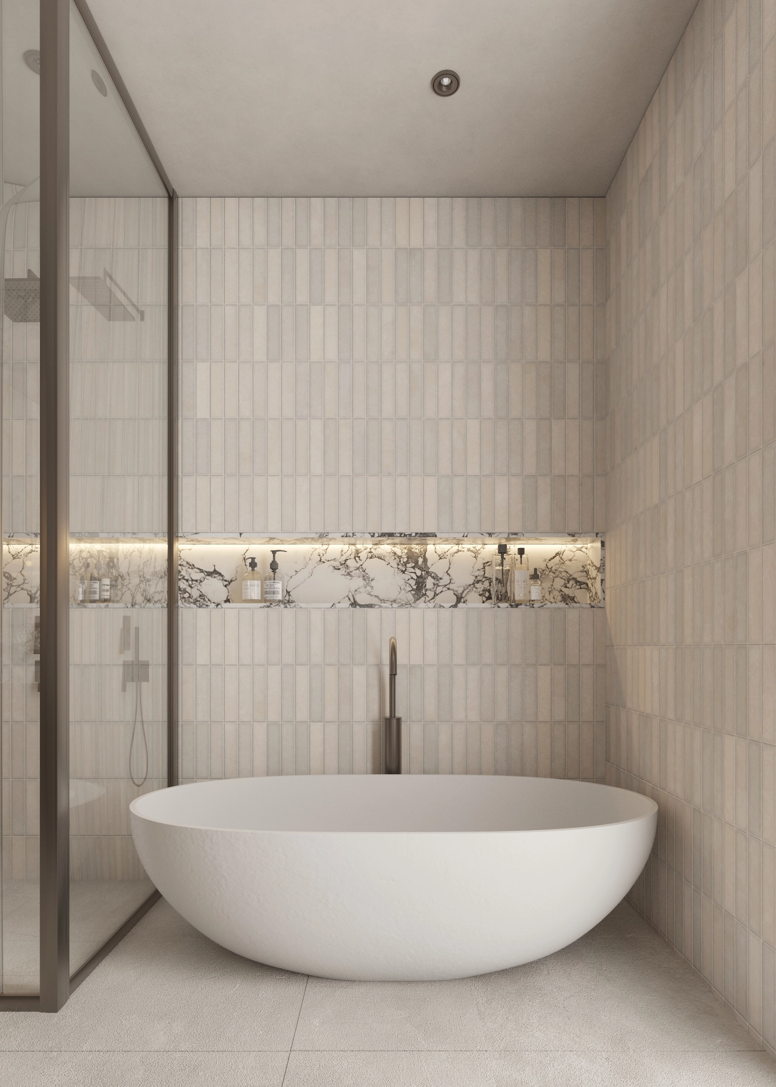 Freestanding bath centred against a softly lit tiled wall