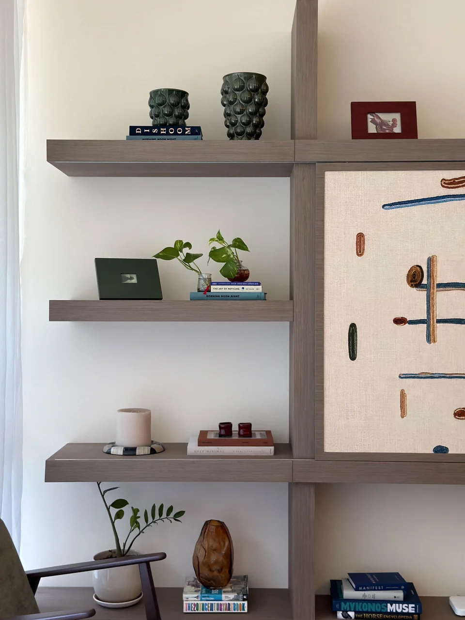 Open left display shelves styled with books, ceramics and small plants