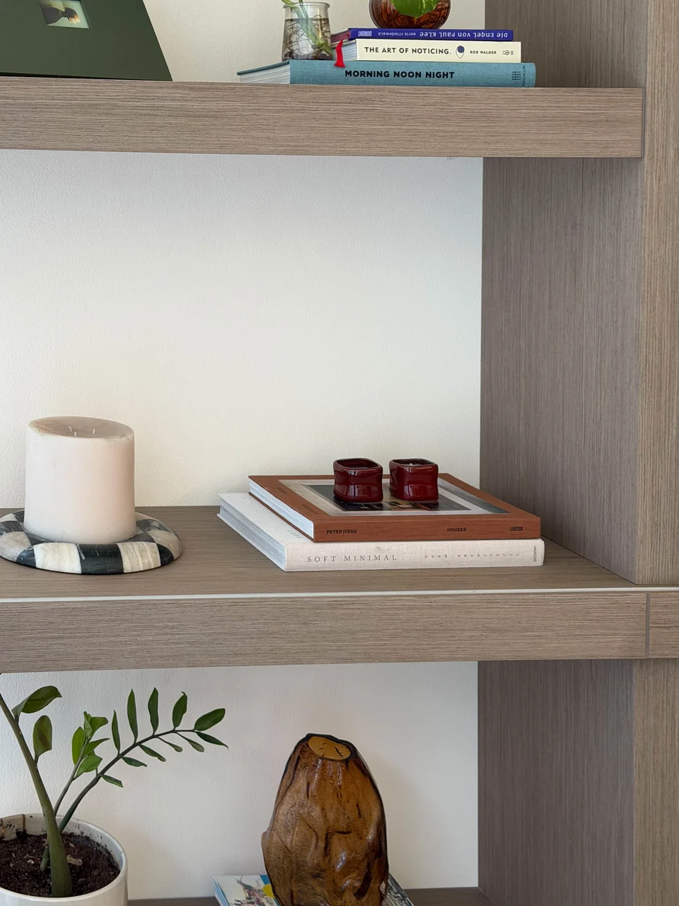 Low timber shelf styled with a candle, books and sculptural objects