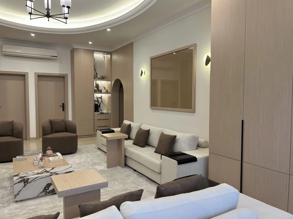Angled view of the completed Mirdif villa living room with layered seating and timber storage