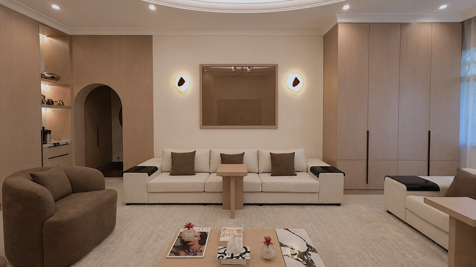 Completed Mirdif villa living room with a circular ceiling, neutral seating and full-height joinery