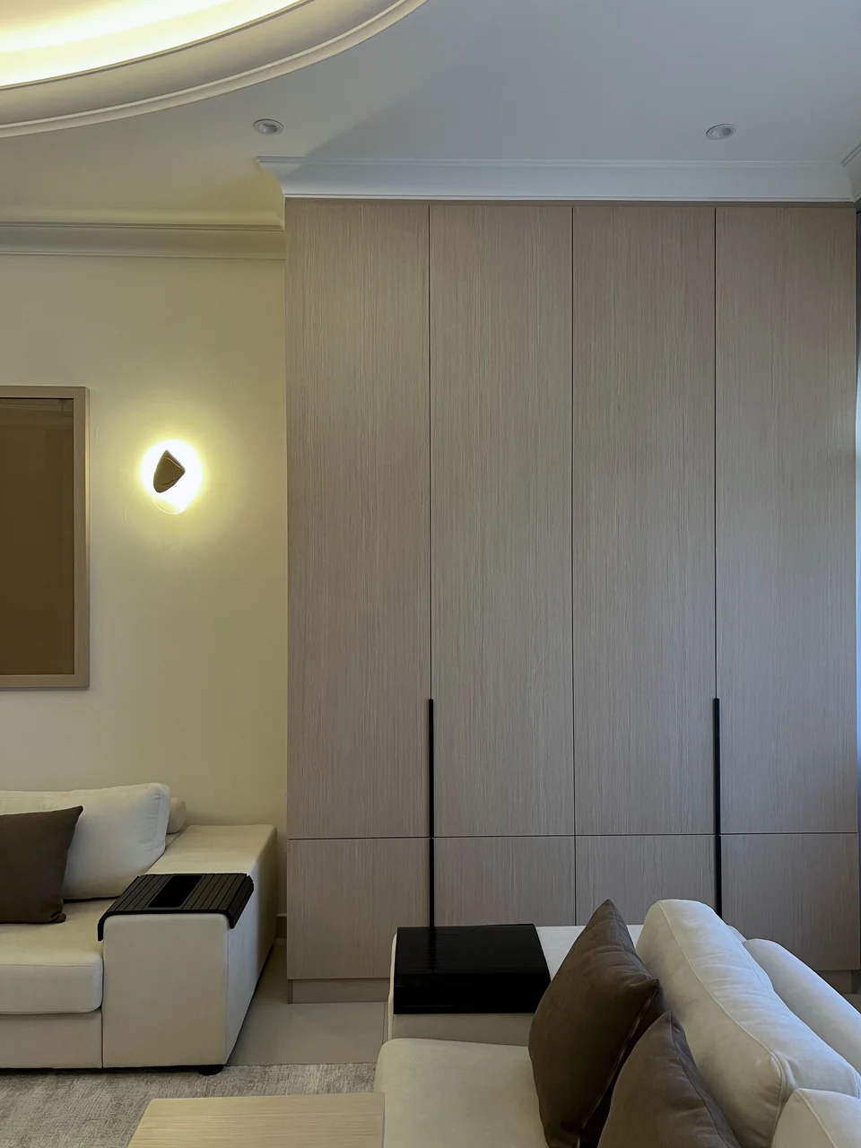 Full-height timber storage joinery beside the completed Mirdif villa living room
