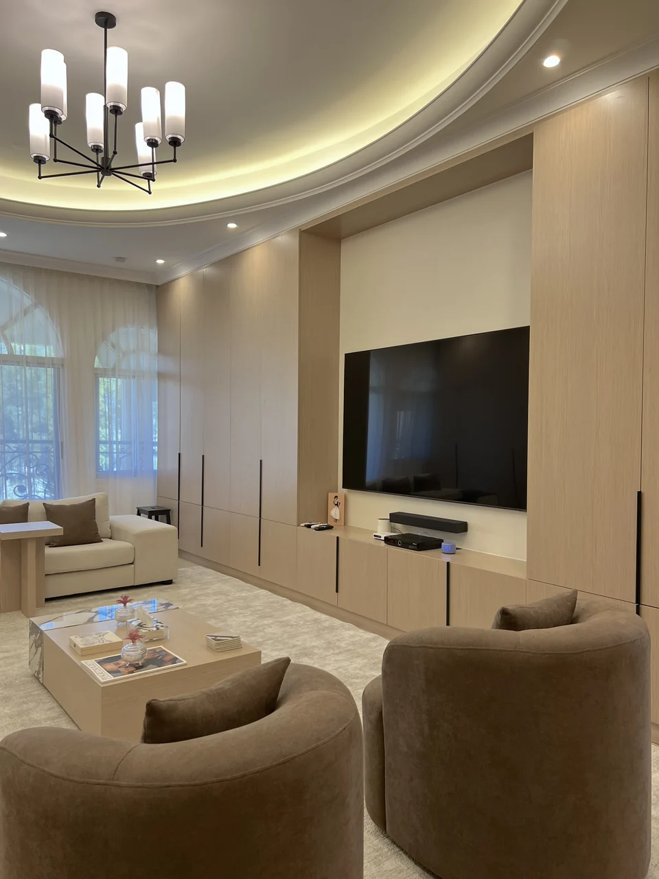 Completed Mirdif villa media wall beneath a curved illuminated ceiling