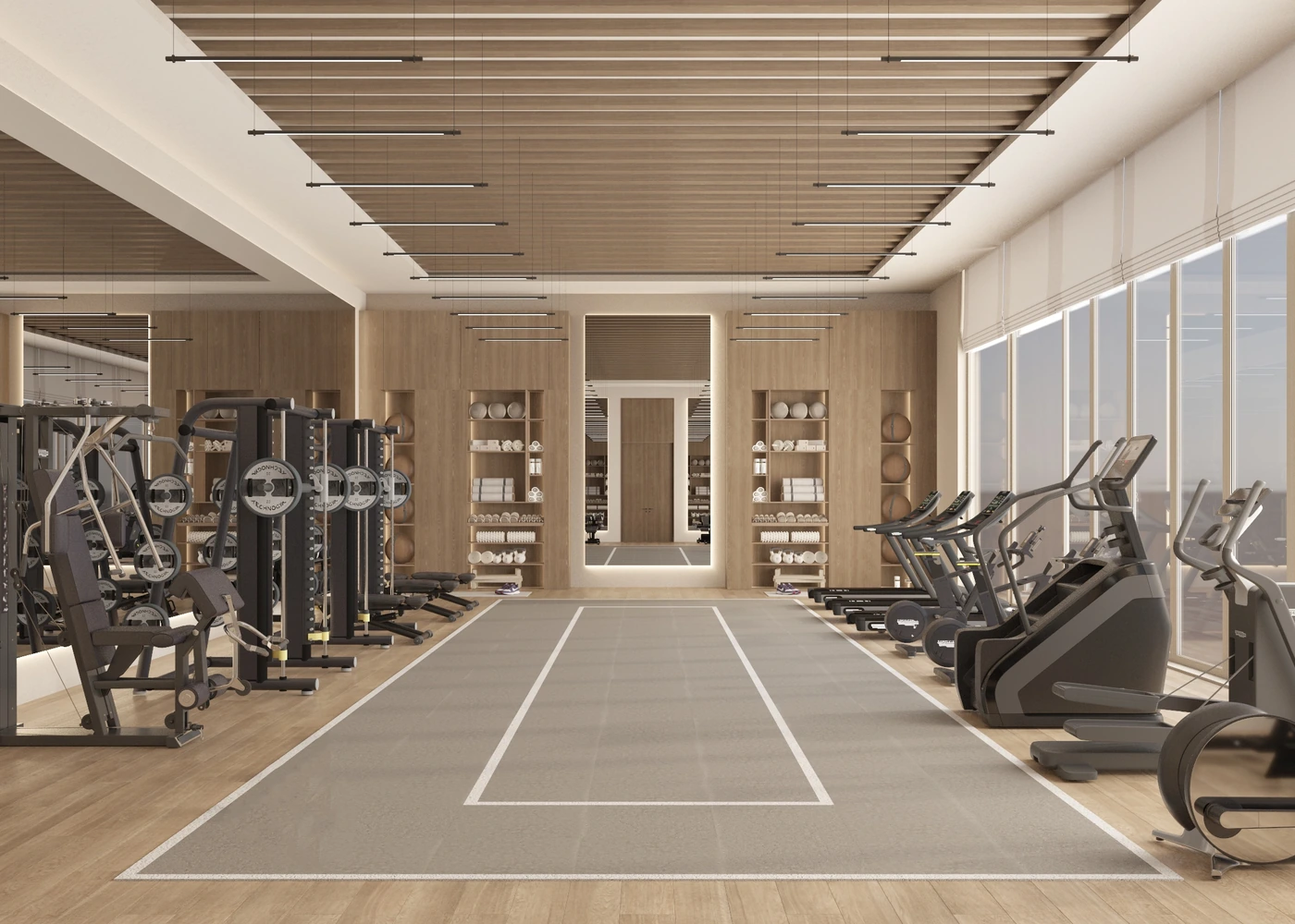 Long view through the gym with cardio equipment beside full-height windows